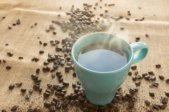 Xícara de café sobre plano com grãos de café