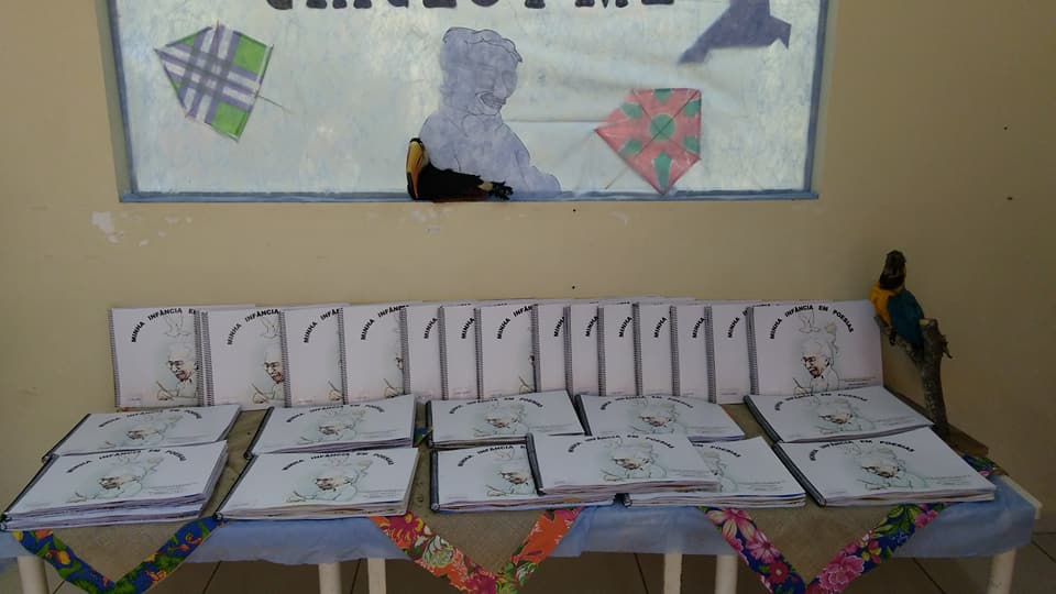 Mesa preparada com as pastas (portfólios) contendo explicações sobre o projeto para as famílias e as atividades das crianças. 